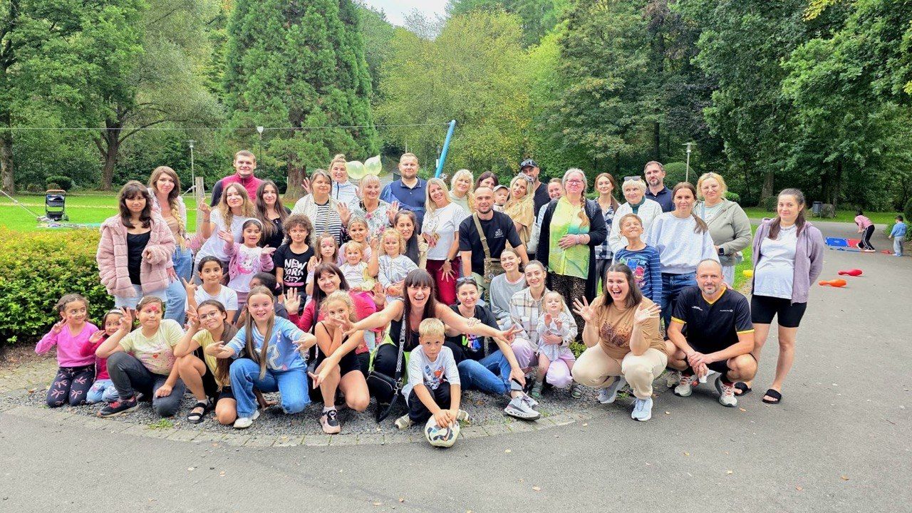 A large group of children and adults together in a park.