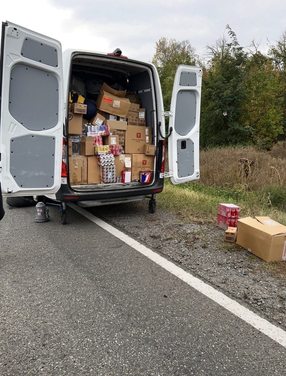 A van with its back doors open, packed with boxes.